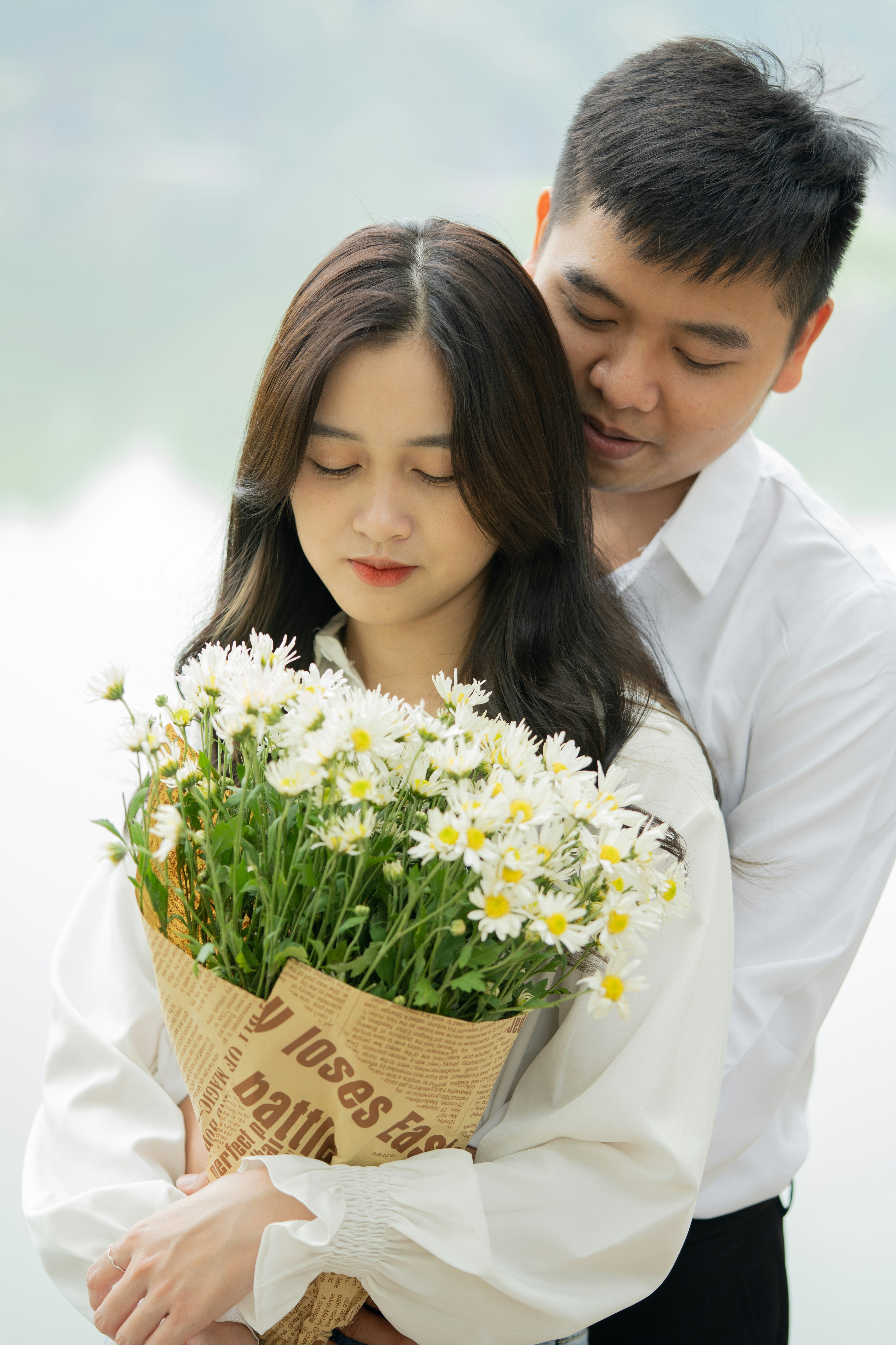 a man and woman holding flowers